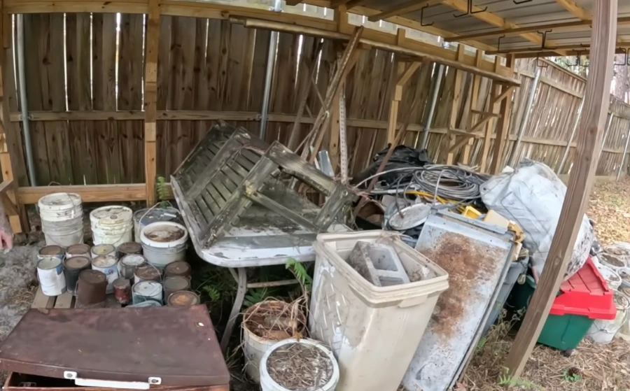 Broken fencing and tree branches piled up after storm damage