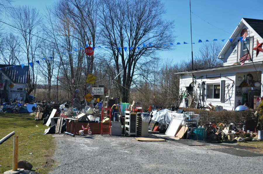 Crew hauling drywall and lumber scraps out of a driveway